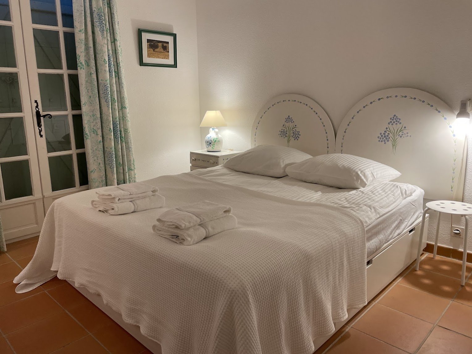 The ground-floor bedroom — double bed, hand-painted floral headboards