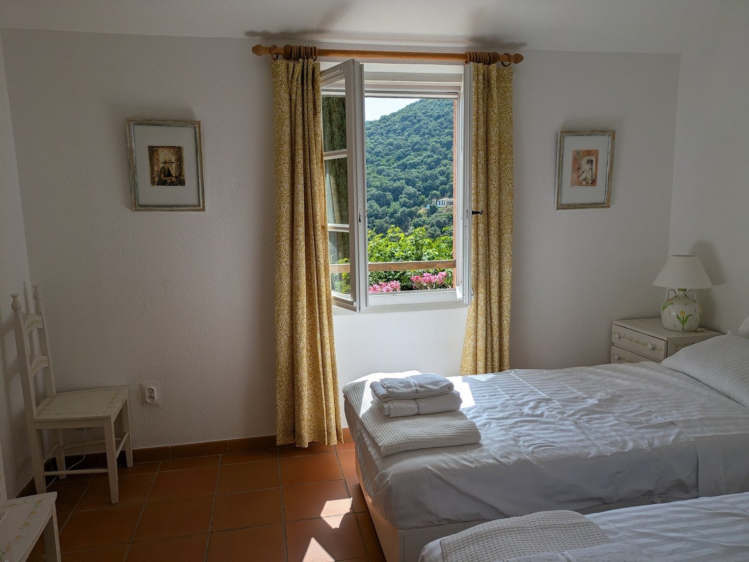 The first-floor bedroom — twin beds, window onto the hills