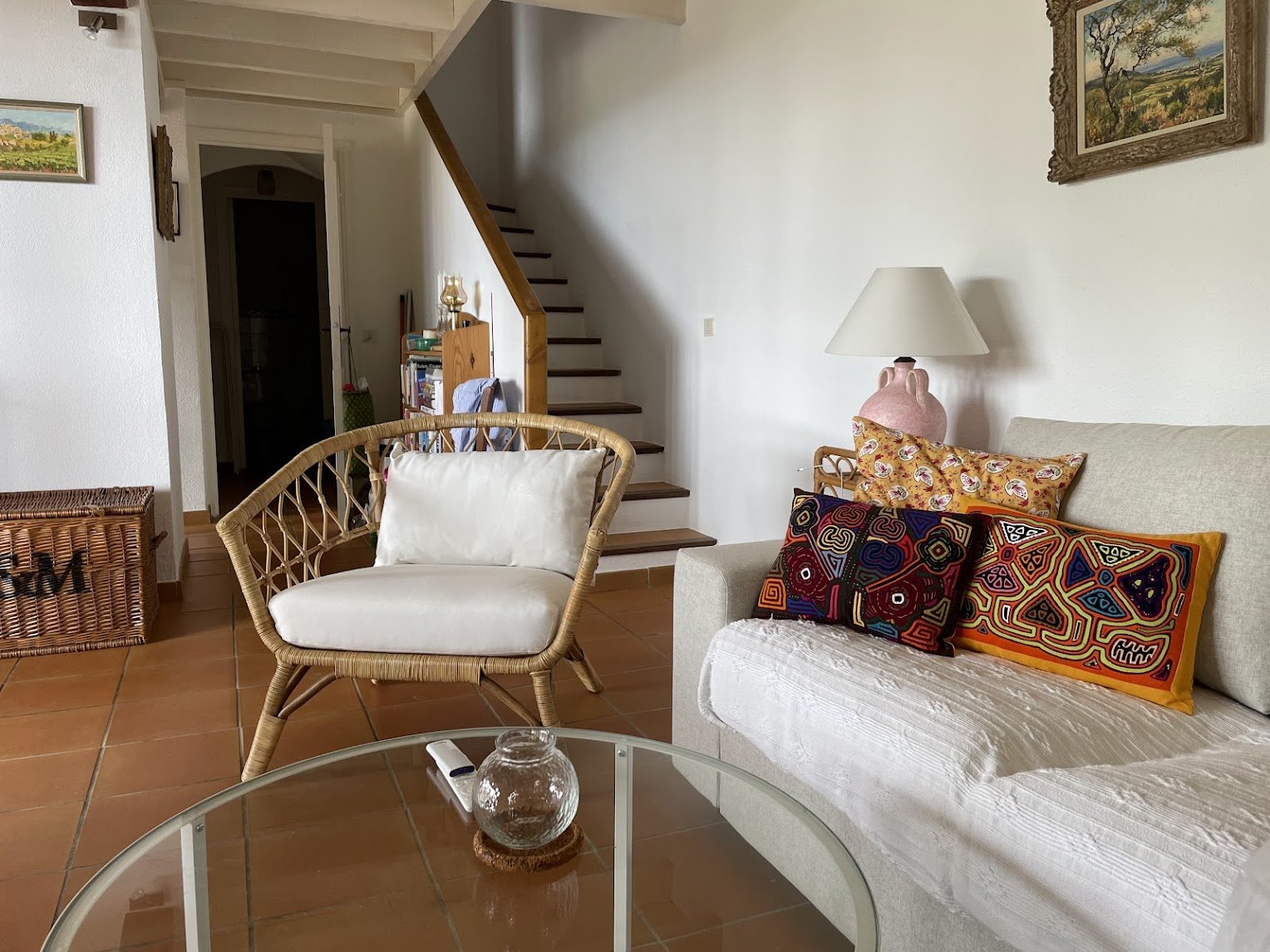A corner of the living room — rattan chair and tile floor