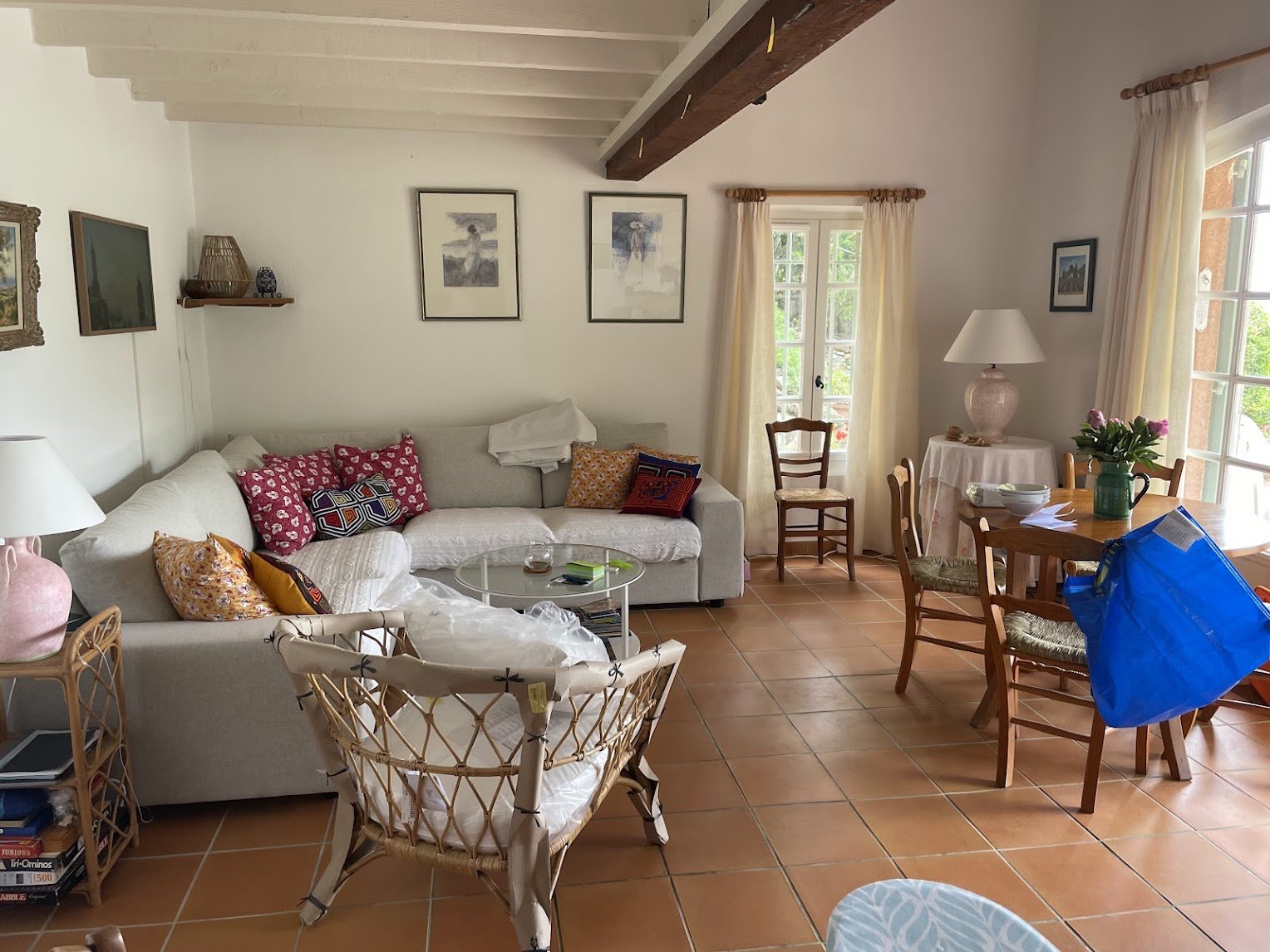 The open-plan living room with exposed beams and terracotta floors